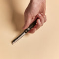 Hand holding a Higonokami pocket knife with blade open