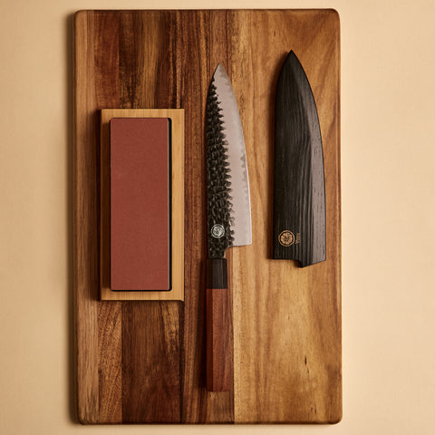 Yuzu Knives Japanese steel Gyuto starter kit — knife, sharpening stone, and saya on a cutting board