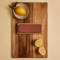 Dual-sided knife sharpening stone on a walnut cutting board with lemons