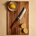 Nakiri knife from the four knife set on a cutting board with lemons