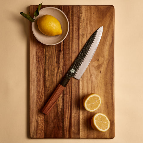Yuzu Knives Japanese steel Gyuto chef knife on a walnut cutting board with lemons