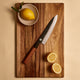 Yuzu Knives Japanese steel Gyuto chef knife on a walnut cutting board with lemons