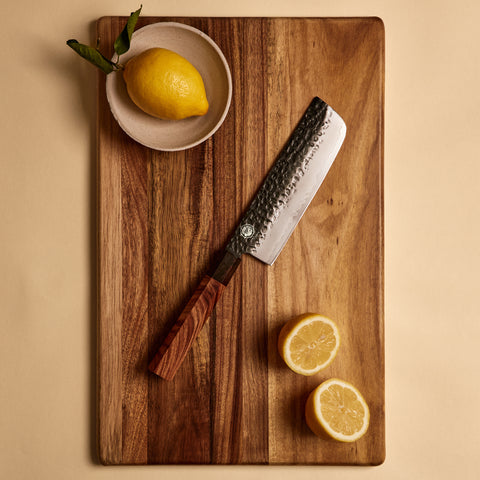 Yuzu Knives Japanese steel Nakiri vegetable knife on a walnut cutting board with lemons
