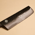Close-up of Nakiri kurouchi hammered finish on AUS-10 steel blade