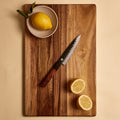 Yuzu Knives Japanese steel Petty paring knife on a walnut cutting board with lemons