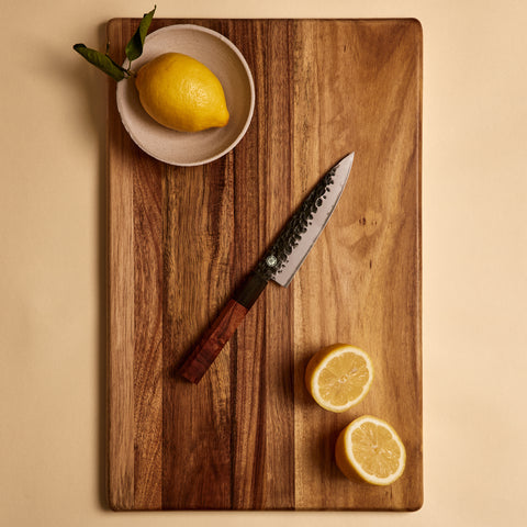 Yuzu Knives Japanese steel Petty paring knife on a walnut cutting board with lemons