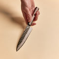 Hand holding a Petty knife showing its compact kurouchi blade