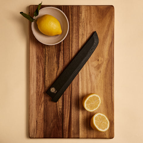 Bread knife saya sheath on a cutting board with lemons